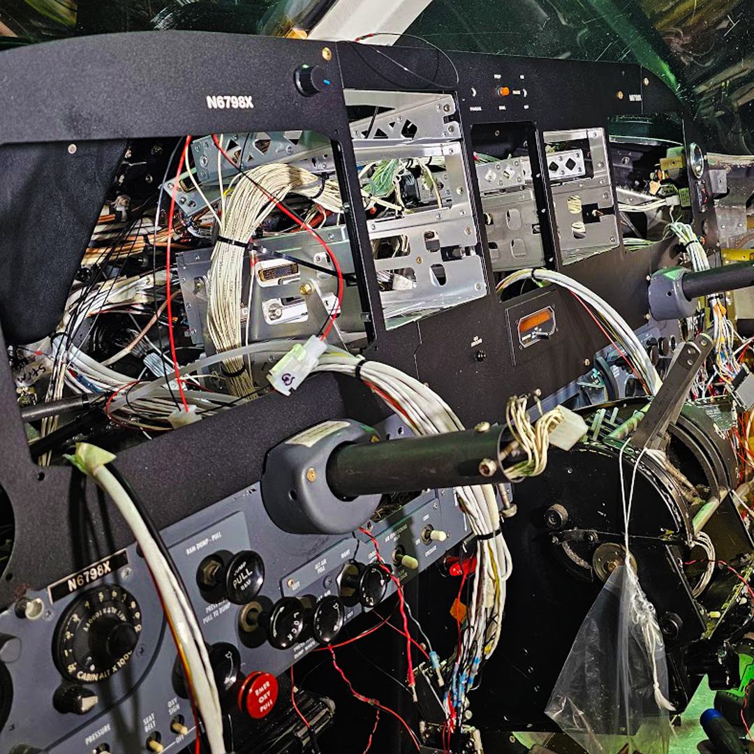 Image of technicians troubleshooting avionics in an aircraft.